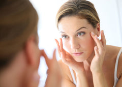 woman looking into mirror